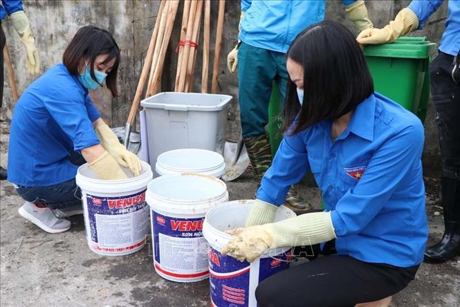Thanh niên tình nguyện thị trấn Gia Lộc chuẩn bị chế phẩm sinh học để xử lý rác thải sinh hoạt. 