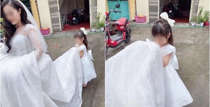 Bé gái mặt buồn thiu nâng váy cưới cho mẹ đi lấy chồng, mọi người cứ bảo trẻ con không biết gì